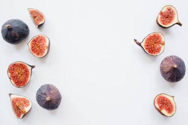 Yaratıcı dilimlenmiş desen ve beyaz arka planda olgun incirler. Meyve illüstrasyonu. Yemek fotoğrafı. Üst Manzara 'da dümdüz yatıyordu. Boşluğu kopyala.