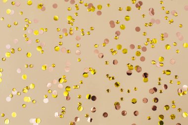 Bej kağıtlı altın konfeti. Bayram arkaplanı. Doğum günün kutlu olsun, yeni yıl. Düz konum, üst görünüm, kopyalama alanı.