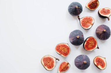 Yaratıcı dilimlenmiş desen ve beyaz arka planda olgun incirler. Meyve illüstrasyonu. Yemek fotoğrafı. Üst Manzara 'da dümdüz yatıyordu. Boşluğu kopyala.