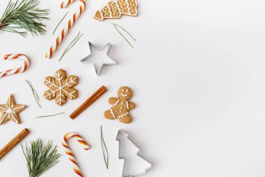 Noel, kış, yeni yıl kompozisyonu. Firavun ağacı dalları, tarçın çubukları, şekerler, beyaz arka planda zencefilli ekmek. Düz konum, üst görünüm, kopyalama alanı