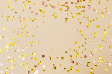 Bej kağıtlı altın konfeti. Bayram arkaplanı. Doğum günün kutlu olsun, yeni yıl. Düz konum, üst görünüm, kopyalama alanı