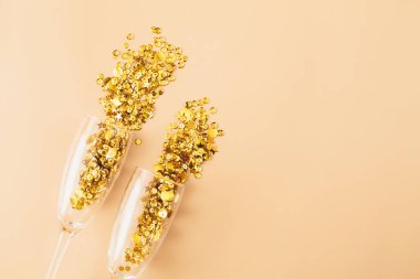 Bej arka planda altın renkli konfeti süslemeli gözlük. Düz konum, üst görünüm, kopyalama alanı. Parti konseptini kutla.