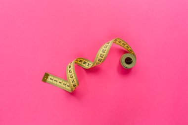 Pembe arka planda mezura. Diyet ve kilo kaybı konsepti düz konum, üst görünüm, kopyalama alanı.