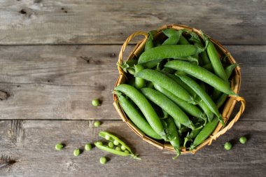 Kırsal ahşap arka planda yeşil bezelye. Düz konum, üst görünüm, kopyalama alanı.