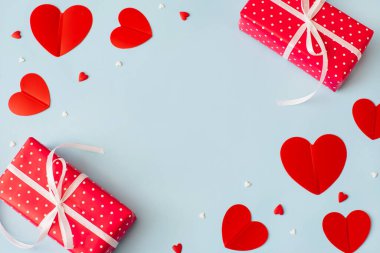 Sevgililer Günü geçmişi 14 Şubat. Hediyeler, konfetiler, pastel mavi arka planda kırmızı kalpler. Sevgililer Günü konsepti. Düz konum, üst görünüm, kopyalama alanı.