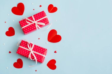 Sevgililer Günü geçmişi 14 Şubat. Hediyeler, konfetiler, pastel mavi arka planda kırmızı kalpler. Sevgililer Günü konsepti. Düz konum, üst görünüm, kopyalama alanı.