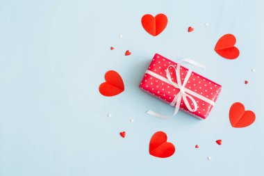 Sevgililer Günü geçmişi 14 Şubat. Hediyeler, konfetiler, pastel mavi arka planda kırmızı kalpler. Sevgililer Günü konsepti. Düz konum, üst görünüm, kopyalama alanı.