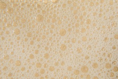 Bej arka planda beyaz kozmetik köpük dokusu. Temizleyici, şampuan köpüğü, yıkama - sıvı sabun, duş jeli, şampuan. Gül arka planında beyaz köpük dokusu. Kopyalama alanı olan kozmetik pankartı.