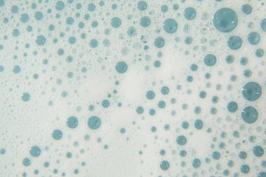 Mavi arka planda beyaz kozmetik köpük dokusu. Temizleyici, şampuan köpüğü, yıkama - sıvı sabun, duş jeli, şampuan. Gül arka planında beyaz köpük dokusu. Kopyalama alanı olan kozmetik pankartı