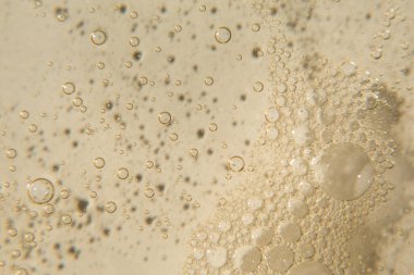 Bej arka planda kabarcıklar olan kozmetik doku. Temizleyici, şampuan, yıkama - sıvı sabun, duş jeli, hyaluronik asit, serum. Kozmetik afişi