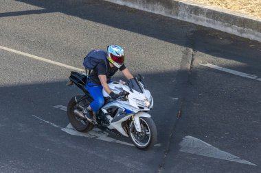 Şehir yolunda beyaz ve mavi bir bisiklete binen adam