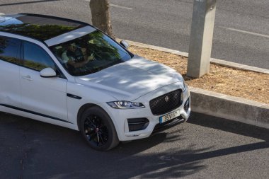 # Beyaz jaguar... # #... gölgeli asfalt sokağa park etmiş. #