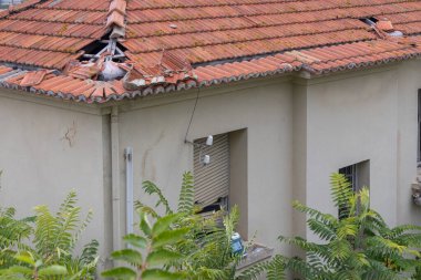 Doğal bir felaketten sonra onarılması gereken bir binanın çatısı hasar görmüş.