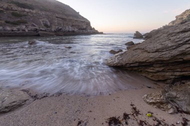Okyanus dalgaları Samarra sahilinde büyük kayaların yanında kıyıya vuruyor.