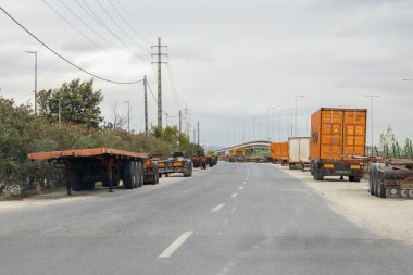 Karavan ve nakliye konteynırları bulutlu bir gökyüzünün altında yol boyunca park halindeydi.