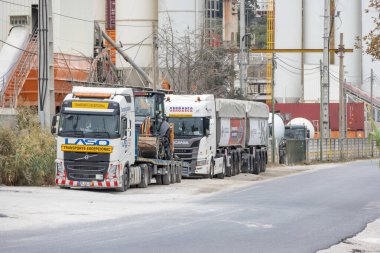 Endüstriyel çimento fabrikasının önüne park etmiş kamyonlar.