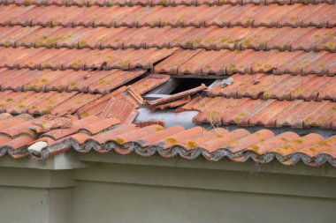 Kırık kiremitler bir delik açıyor, acil ev onarımı gerekiyor.