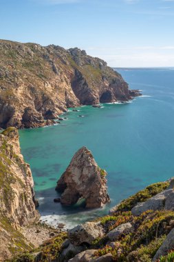 Atlantik Okyanusu dalgaları Cabo da Roca yakınlarındaki Lourical sahilindeki kaya kemerine çarpıyor.