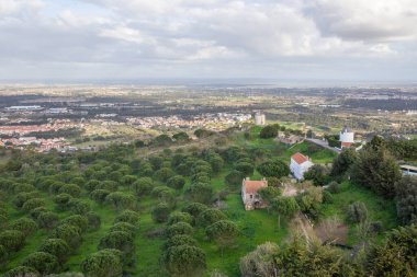 Yel değirmenleri, küçük evler ve uzak bir kasaba olan Palmela Kalesi 'nin yüksek panoramik manzarası.