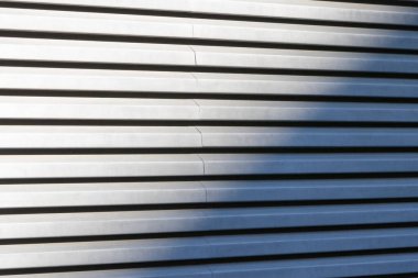 Paralel çizgiler ve gölgelerle donatılmış metal cephesi soyut arkaplan