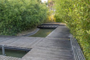 Su bahçeleri, bambu ve su kanallarında dolambaçlı ahşap geçitler içerir, sakin bir yol oluşturur.