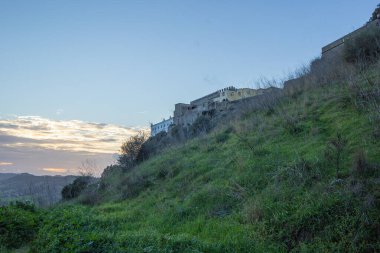Güneş batarken Portekiz 'deki bir tepenin kırsal manzarasına bakan Palmela Kalesi