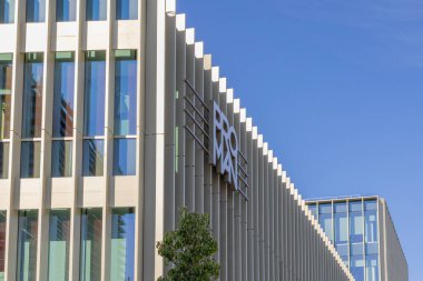 Exeo ofis kampüsündeki modern proman ofis binası. Mavi gökyüzünün altında mimari bir görünüme sahip.