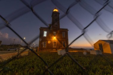 Penedo da saudade deniz feneri gecenin geç saatlerinde tel örgülerin arkasında aydınlanır.