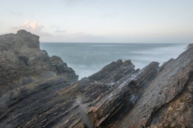 Yumuşak, bulanık okyanus dalgaları gibi engebeli kayalar Sainy Peter of Moel 'de akıyor.