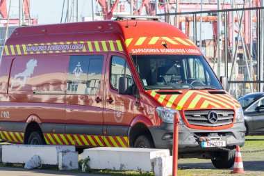 Bright red lisbon fire brigade rescue van parked near harbor during duty hours
