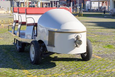 Limandaki turlar için otlak araziye park edilmiş beyaz klasik gezi treni.