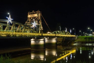 Alcacer Sal Metal Köprüsü gece Sado Nehri 'ne yansıyan yılbaşı ışıklarıyla parıldıyor