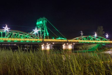 Alcacer Sal Metal Köprüsü 'nü yeşil ışıklarla ve Sado Nehri üzerinde noel süslemeleriyle süslüyor.