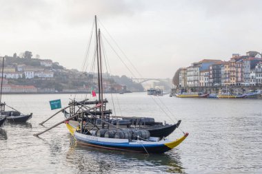 Rabelo tekneleri şarap fıçılarıyla Douro nehrinde yüzer, ribeira görünür hale gelir.