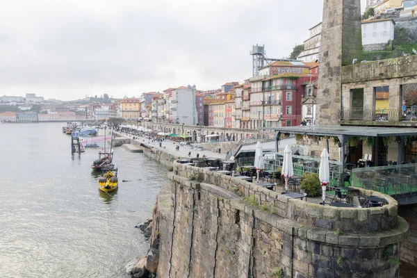 Ribeira bölgesinde renkli binalar, nehir kenarındaki gezinti güvertesi ve Douro Nehri 'ndeki geleneksel tekneler sergileniyor.