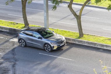 Renault Megane teknolojili elektrikli cip gündüz vakti bir şehir sokağına park edilmiş.