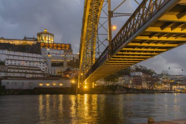 Aydınlatılmış dom luis Köprüsü Alacakaranlıkta Douro nehrinde yansımalar yaratıyor