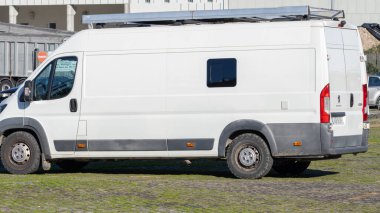 Çatı rafı, off-road lastikleri ve arka kapıları olan bir karavan.