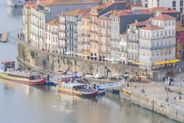 Douro nehir tekneleri, canlı bir şehir manzarası sunan ribeira bölgesi boyunca demirlediler.