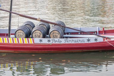 Rabelo teknesi Porto Ferreira limanı şarap fıçılarını Douro nehrinden aşağı taşıyor.