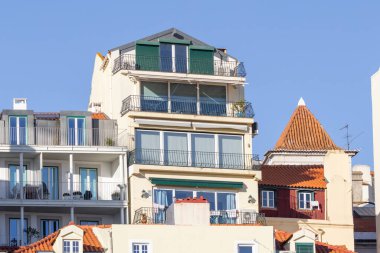 Açık bir gökyüzü altında pencere ve balkonları olan konut binaları içeren Lizbon kentsel mimarisi