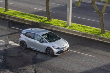 Gümüş kapra doğumlu elektrikli araç asfalt bir yolda şehir merkezinde seyahat ediyor.