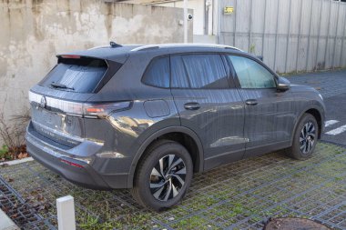 Volkswagen tiguan kompakt SUV yeni model açık havada, geçirgen şebeke döşemesinde park edilmiş.