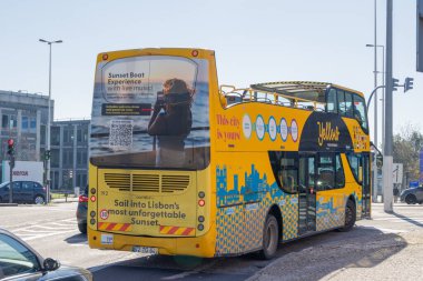 Çift katlı gezi otobüsü Lizbon, Portekiz 'de gün batımı tekne turu düzenliyor.