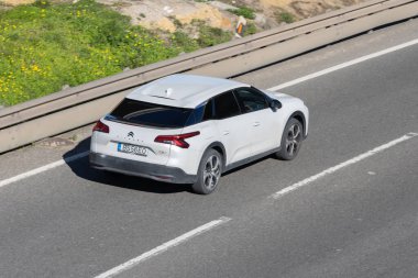 Beyaz citroen c5 x araba gün içinde asfalt bir otoyolda ilerliyor