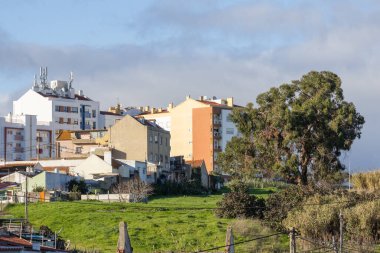 Lizbon şehir manzarası çeşitli binalar ve yeşil yamaçlı bir yerleşim alanı sunuyor.