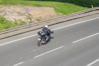 Bir otoyolda motosiklet süren motosikletli gezgin ve araştırmacı.