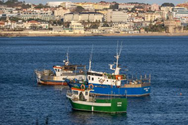 Kıyı kasabası ve sahili arka planda olan körfeze demirlemiş balıkçı tekneleri.