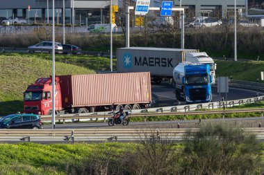 Yoğun bir çok şeritli otoyol kavşağından geçen ağır kamyonlar ve yolcu araçları