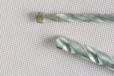 İki endüstriyel sondaj matkabı desenli bir yüzeyde yatıyor.